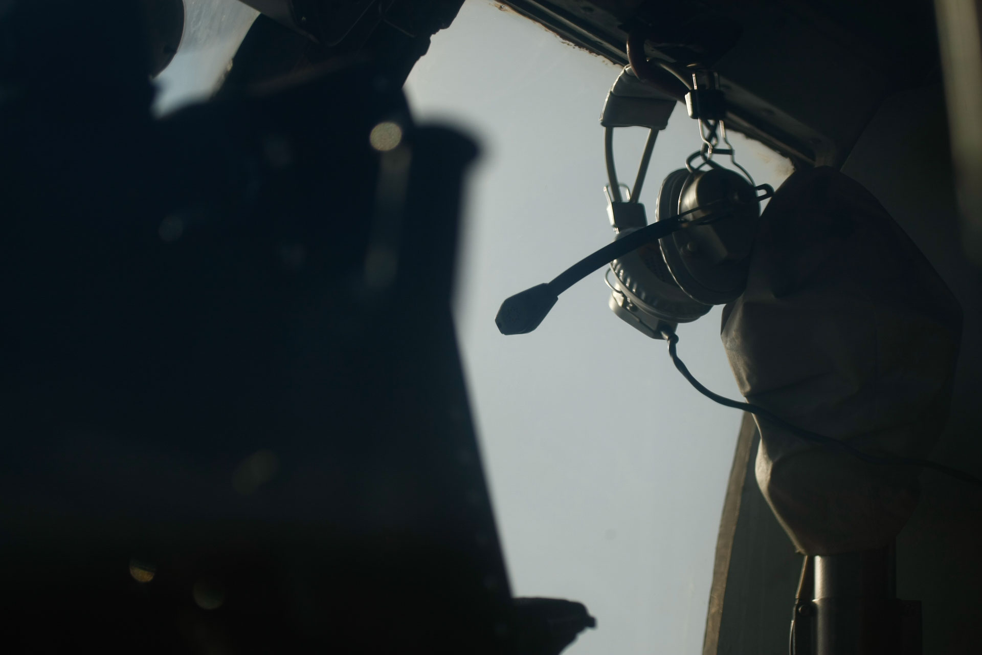 Aviation headset silhouetted in cockpit